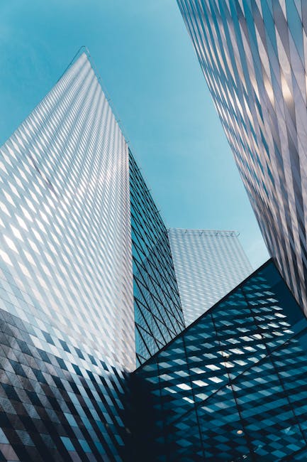 Futuristic skyscrapers in Vilnius with reflective geometric facades under a clear sky.